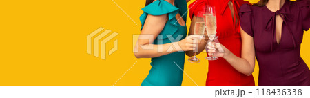 Girls Only Party. Three Pretty Women In Dresses Clinking Glasses Celebrating Bachelorette Standing Over Yellow Background. Studio Shot Girls Only Party. Three Pretty Women In Dresses Clinking Glasses Celebrating Bachelorette Standing Over Yellow Background. Studio Shot 118436338