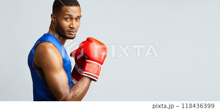 Male Instructor. Portrait of confident black man wearing red gloves posing in boxing stance, panorama, copyspace 118436399