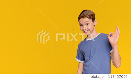 Cute boy showing ok sign, smiling positive, orange studio background Cute boy showing ok sign, smiling positive, orange studio background 118437093