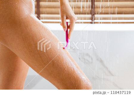 Depilation and body care. Woman shaving legs, taking shower at home, closeup Depilation and body care. Woman shaving legs, taking shower at home, closeup 118437119