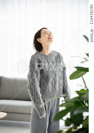 リビングで伸びをする女性 リビングで伸びをする女性 118438290