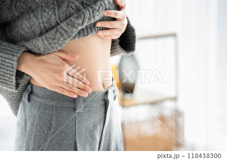 お腹を触る女性　ダイエット　手元 118438300