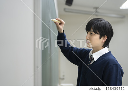 チョークで板書する男子学生 118439512