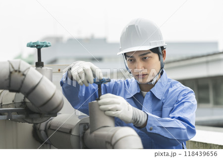 ビルメンテナンス　イメージ　給排水設備の点検作業をする若い男性 118439656