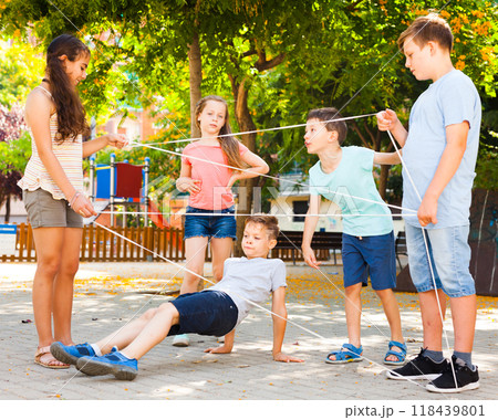Interesting children's games. Boy carefully passes through a tangled rope 118439801