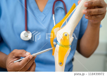 Asian doctor present knee joint model for elderly patient to surgery orthopedic. Asian doctor present knee joint model for elderly patient to surgery orthopedic. 118439972