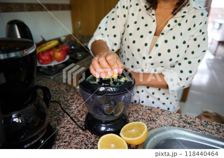 Woman squeezing fresh lemons with a citrus juicer in rustic kitchen for homemade lemonade or healthy cooking Woman squeezing fresh lemons with a citrus juicer in rustic kitchen for homemade lemonade or healthy cooking 118440464