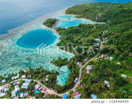 Ocean coastline with blue hole in big lagoon and village, scenic landscape in Indonesia. Aerial view 118440493