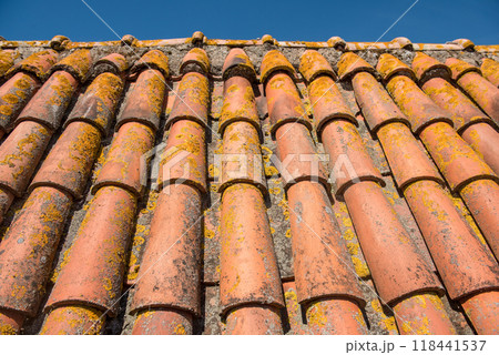 Clay tiles. Close-up of a clay tile roof against a blue sky 118441537