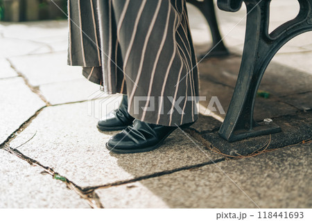 公園のベンチに座る女性の足元 公園のベンチに座る女性の足元 118441693