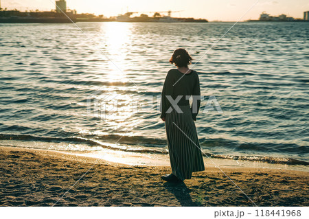 海で夕日を眺めて歩く女性 海で夕日を眺めて歩く女性 118441968