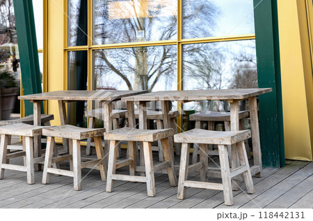 Wooden tables and chairs on the veranda. 118442131