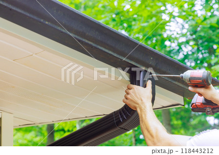 Assembling installing gutter channels on roof of home Assembling installing gutter channels on roof of home 118443212