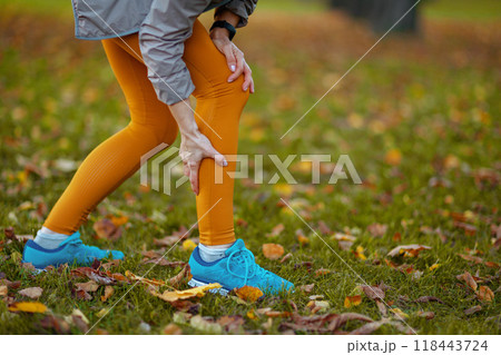 Elegant woman in fitness clothes in park having leg pain 118443724