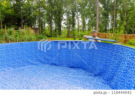 Constructing swimming pool in backyard of house 118444042