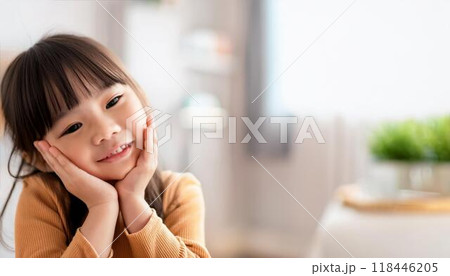 頬杖をついている笑顔の幼い少女 118446205