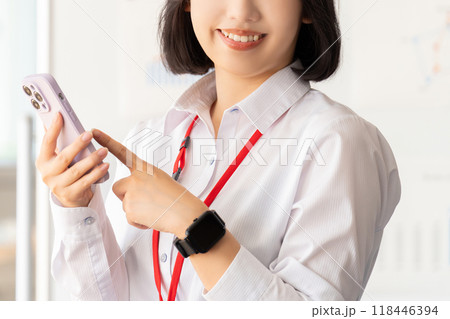 笑顔でスマホを持つ若いビジネスウーマン 118446394