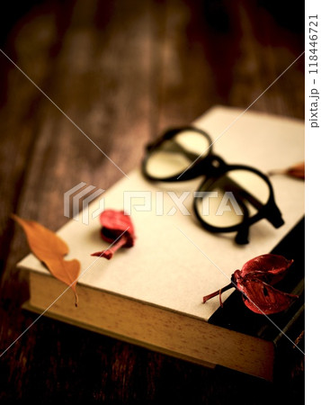 読書　秋　冬　木製のテーブルに置かれた本と眼鏡と枯れ葉 118446721