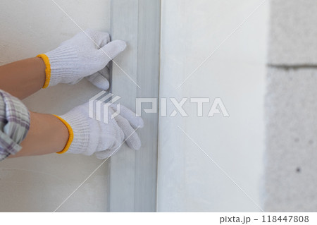 Concept Checking the evenness of a wall using a rule. 118447808