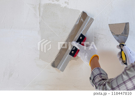 Concepts of puttying using a spatula on the wall. 118447810