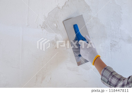 Plastering the wall using a trowel and starting plaster. 118447811