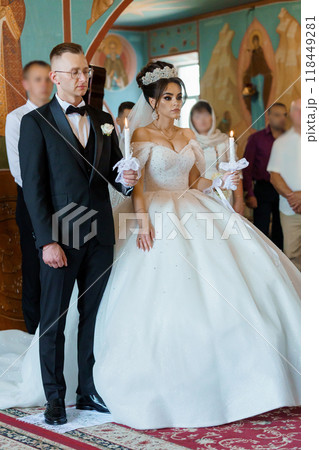 Elegant Orthodox Wedding Ceremony with Bridal Couple Holding Candles Elegant Orthodox Wedding Ceremony with Bridal Couple Holding Candles 118449281
