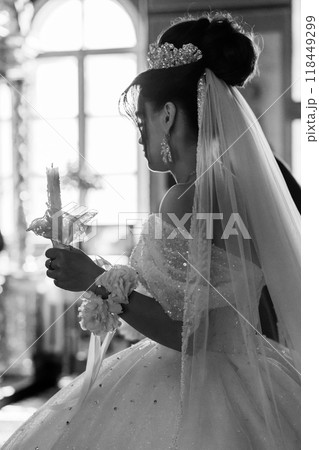Elegant Black and White Portrait of Bride in Sparkling Gown Holding Candle at Wedding Ceremony Elegant Black and White Portrait of Bride in Sparkling Gown Holding Candle at Wedding Ceremony 118449299