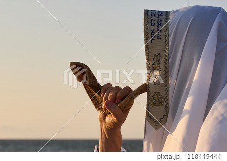 Jewish man blowing the Shofar rams horn on Rosh Hashanah and Yom Kippur day. 118449444