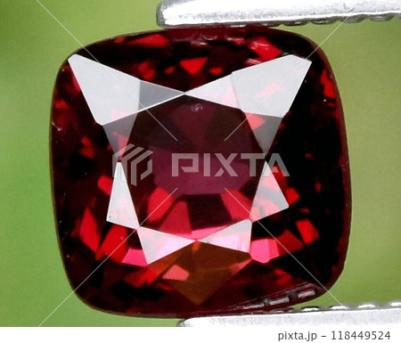 Radiant Red Garnet Gemstone in Pristine Clarity Displayed with Metallic Tweezers Radiant Red Garnet Gemstone in Pristine Clarity Displayed with Metallic Tweezers 118449524