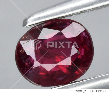 Close-Up of a Gleaming Ruby Gemstone Held by Tweezers 118449525