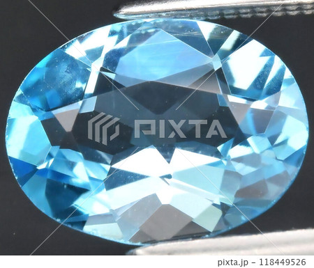 Brilliant Faceted Blue Gemstone Close-Up on Dark Background Brilliant Faceted Blue Gemstone Close-Up on Dark Background 118449526