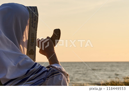 Jewish man blowing the Shofar rams horn on Rosh Hashanah and Yom Kippur day. 118449553