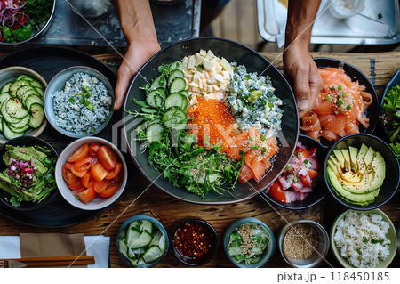 Fresh Sushi Bowl Preparation. Hands holding a bowl filled with sushi ingredients, surrounded by various toppings. Fresh Sushi Bowl Preparation. Hands holding a bowl filled with sushi ingredients, surrounded by various toppings. 118450185