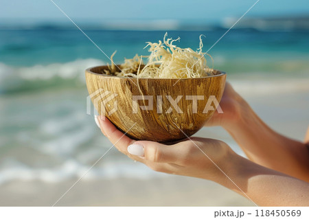 Hand-Held Wooden Bowl at the Beach 118450569