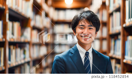 本棚の前に立つスーツ姿の笑顔の若い男性 118452854