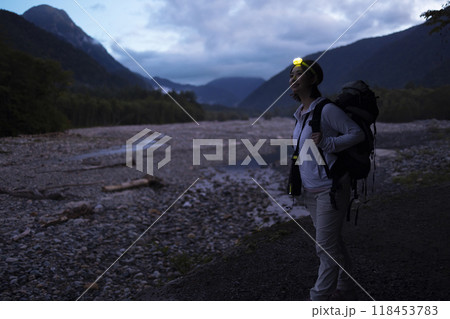 ヘッドライトをつけて登山する女性 118453783