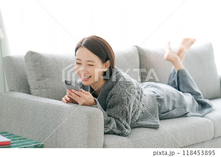 ソファーでスマホを見る40代女性 ソファーでスマホを見る40代女性 118453895