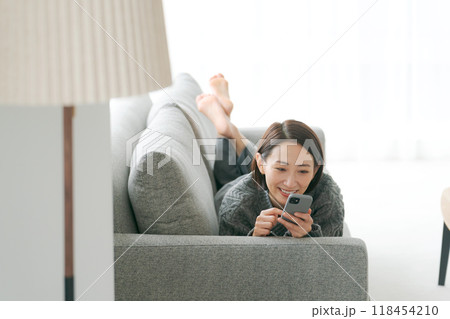 ソファーでスマホを使う女性 118454210