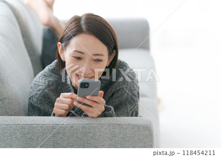 ソファーでスマホを使う女性 118454211