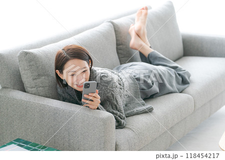 ソファーでスマホを使う女性 118454217
