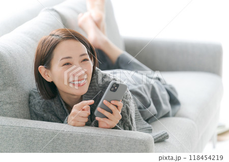 ソファーでスマホを使う女性 ソファーでスマホを使う女性 118454219