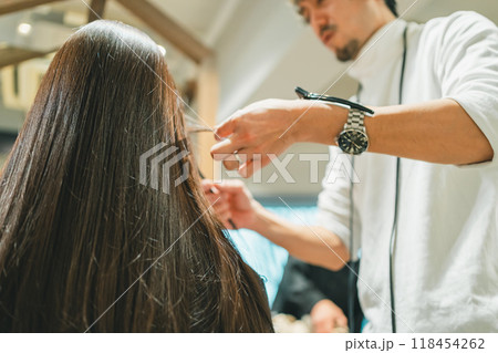 腕時計にダッカールをつけた男性美容師の美容室でのヘアセット 118454262