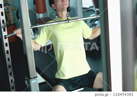 ジムでマシントレーニング（ラットプルダウン）をする若いアジア人の男性 118454391