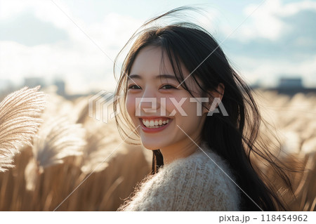 ススキ野原を歩く若い女性 118454962