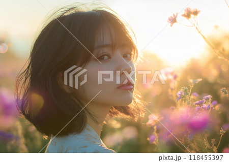 西陽のコスモス畑に立つ女性 118455397