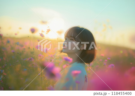 西陽のコスモス畑に立つ女性 118455400