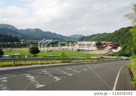山の斜面をカーブしながら駆け下りる急な勾配の舗装道路 118456583