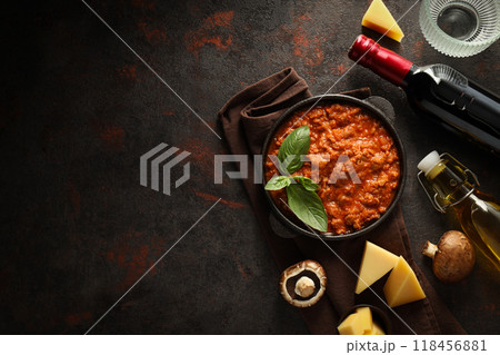 Bolognese sauce in frying pan, ingredients, glasses and bottle of wine on dark background, space for text Bolognese sauce in frying pan, ingredients, glasses and bottle of wine on dark background, space for text 118456881