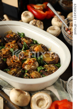 Stuffed mushrooms and ingredients on dark background, close up Stuffed mushrooms and ingredients on dark background, close up 118456929