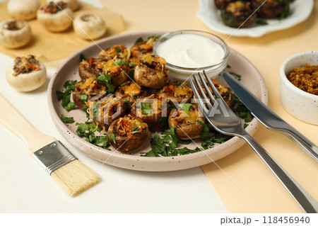 Stuffed mushrooms on plates, sauces and cutlery on light background, close up Stuffed mushrooms on plates, sauces and cutlery on light background, close up 118456940